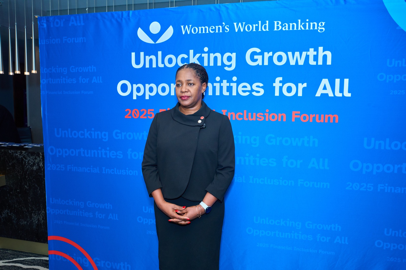 A speaker in front of the event branding